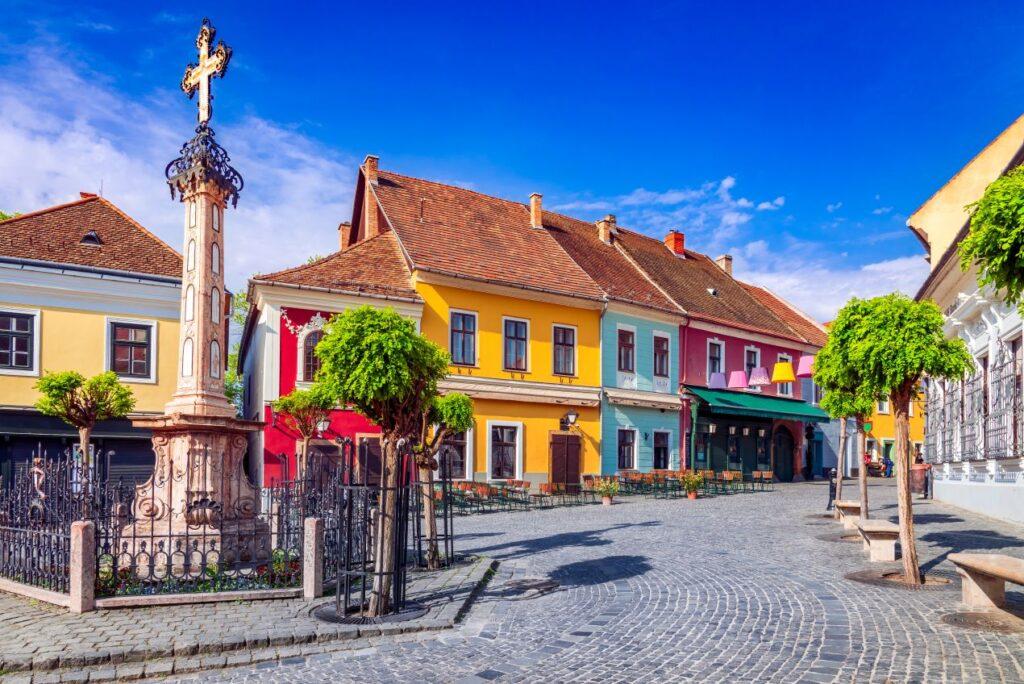 Bunte historische Altstadthaeuser mit Platz und Kopfsteinpflaster – authentische Umgebung beim Haus Kaufen in Ungarn Als Deutscher
